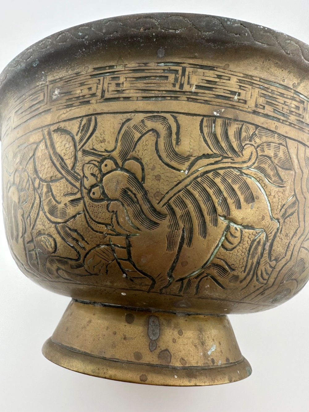 A pair of antique Chinese cast bronze footed bowls decorated with etched bird and lotus leaf motifs beneath key-fret rim borders. View VIII
