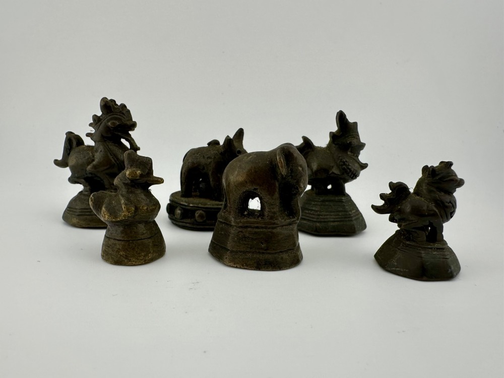 A set of six dark bronze zoomorphic trade weights depicting various animals mounted on octagonal and circular pedestals.
