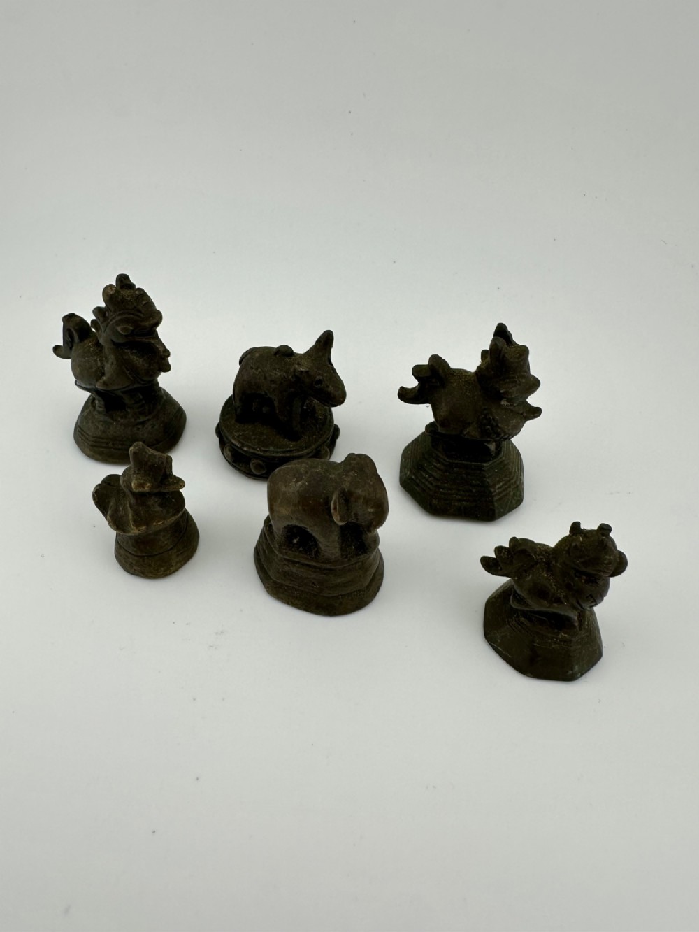 A set of six dark bronze zoomorphic trade weights depicting various animals mounted on octagonal and circular pedestals. View II
