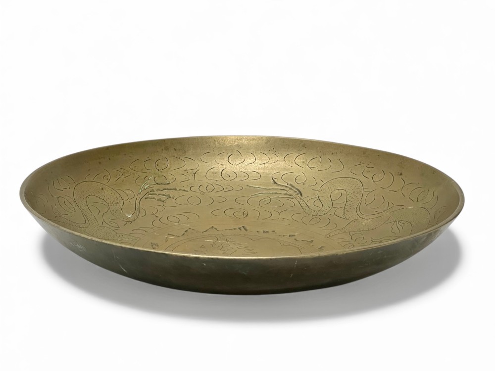 A circular shallow brass dish featuring detailed hand-engraved designs of dragons, clouds, and a central circular motif. View II