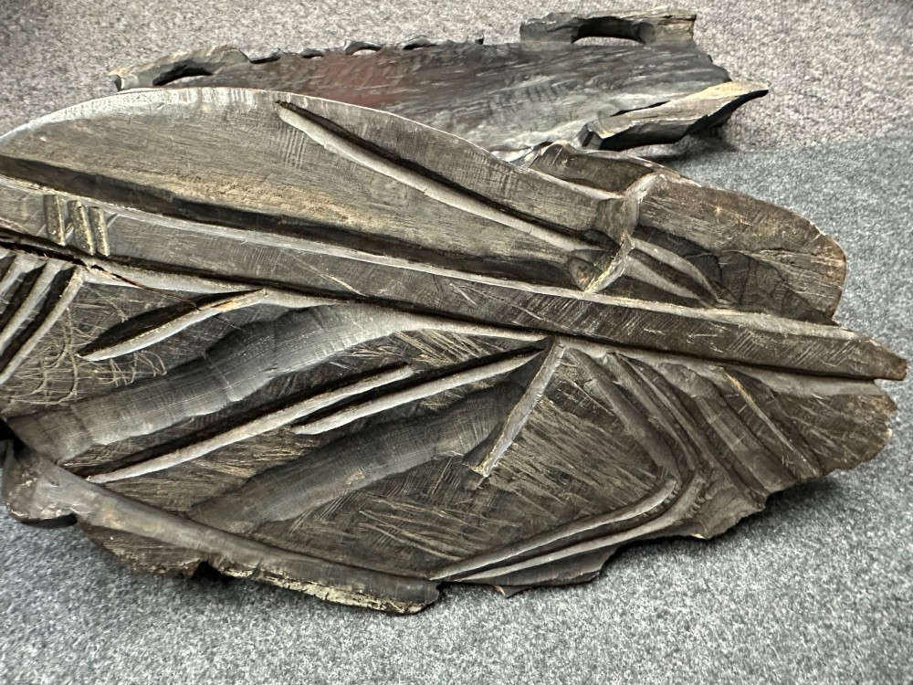 A late Qing Dynasty dark carved hardwood figure depicting a reclining Budai resting on an openwork carved wooden base. View IX
