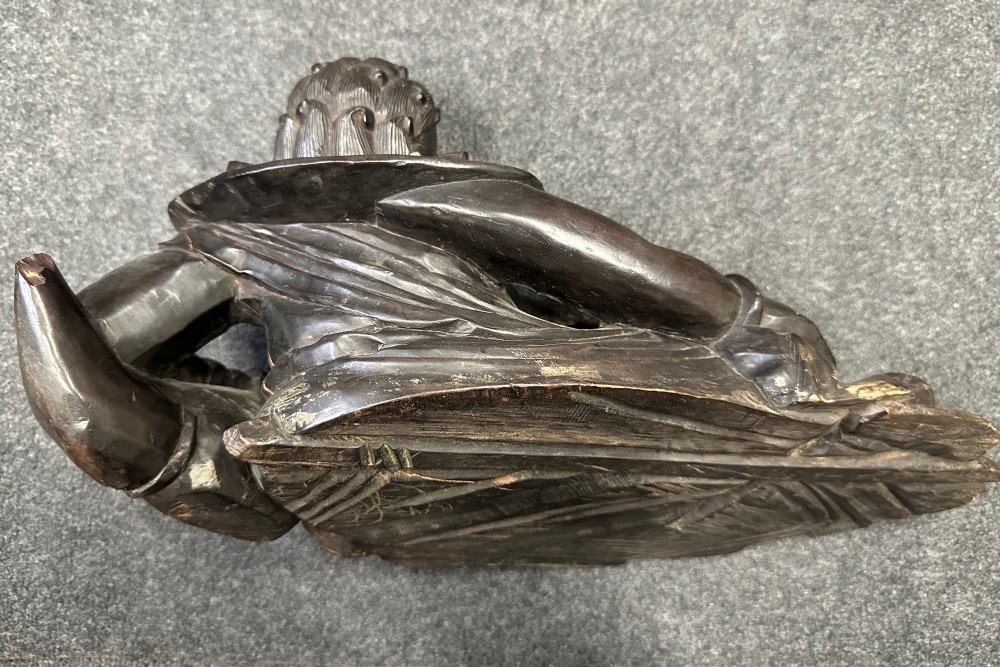 A late Qing Dynasty dark carved hardwood figure depicting a reclining Budai resting on an openwork carved wooden base. View X