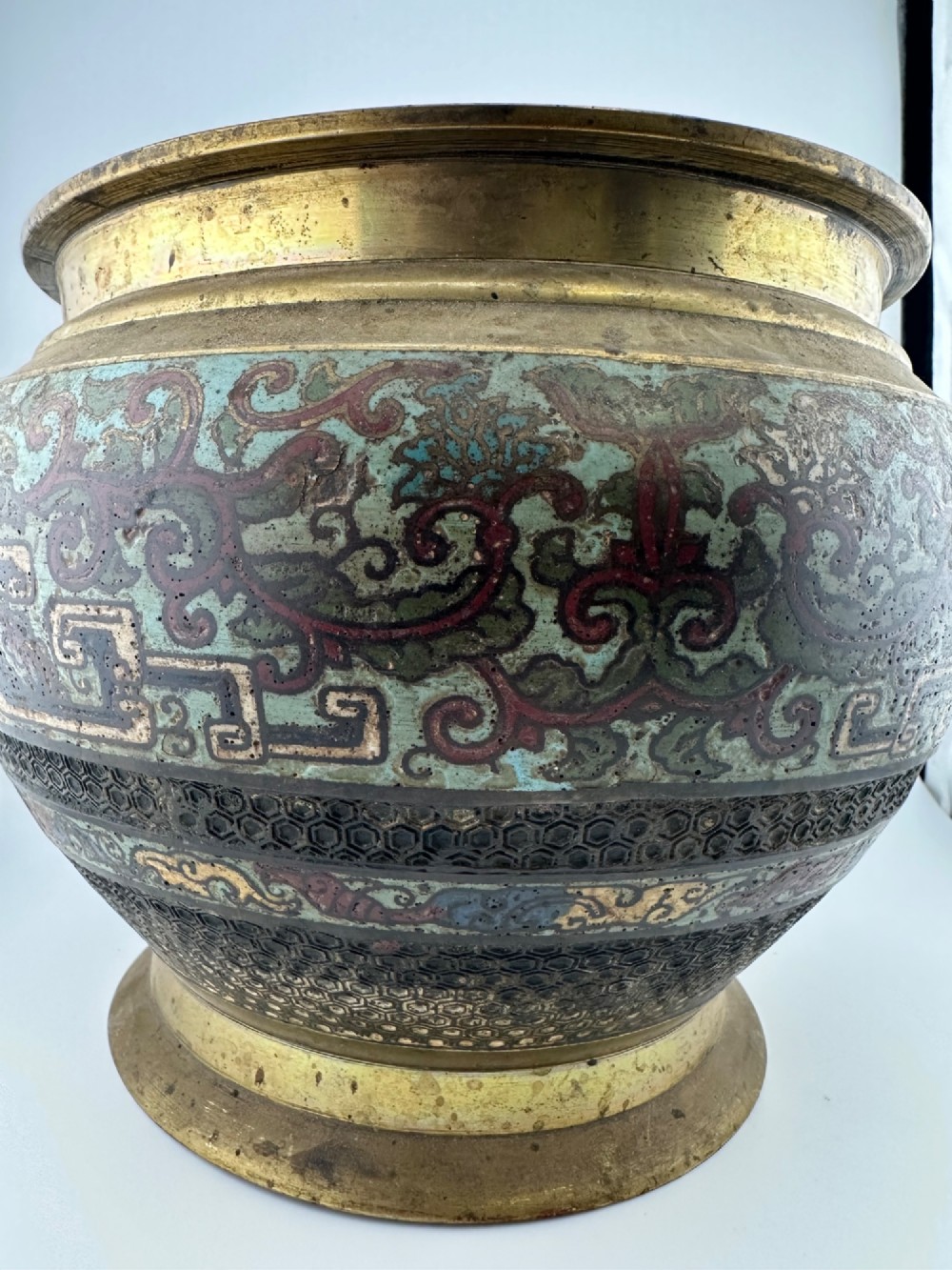 A set of three bulbous antique Chinese bronze jardinieres featuring colourful champleve enamel floral decoration around their midsections. View II