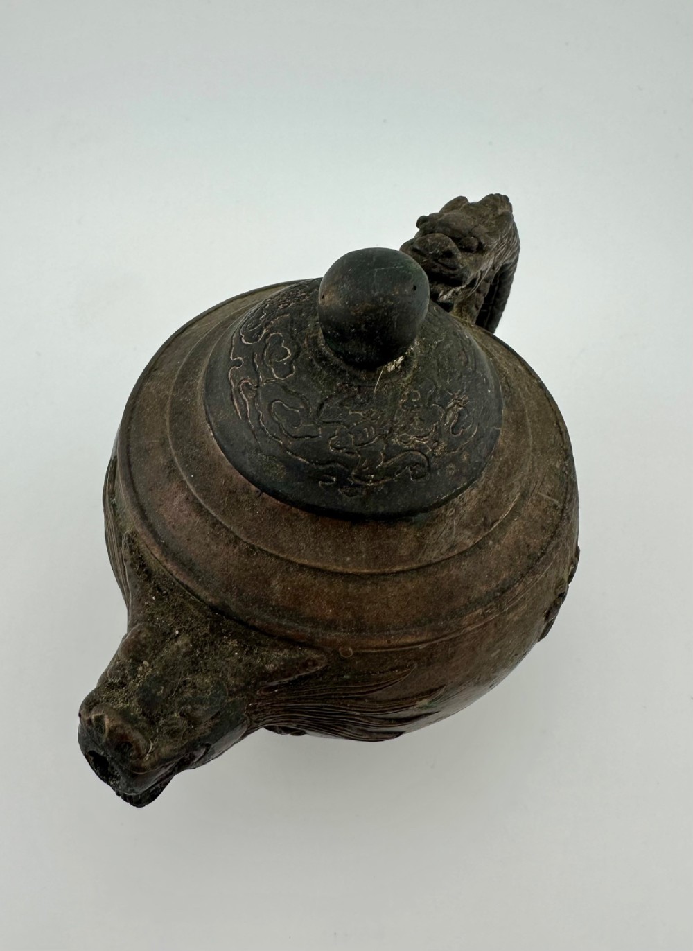 A dark cast bronze Chinese teapot featuring a sculpted dragon handle, a dragon-head spout, and raised Chinese character carvings on the main body. View III