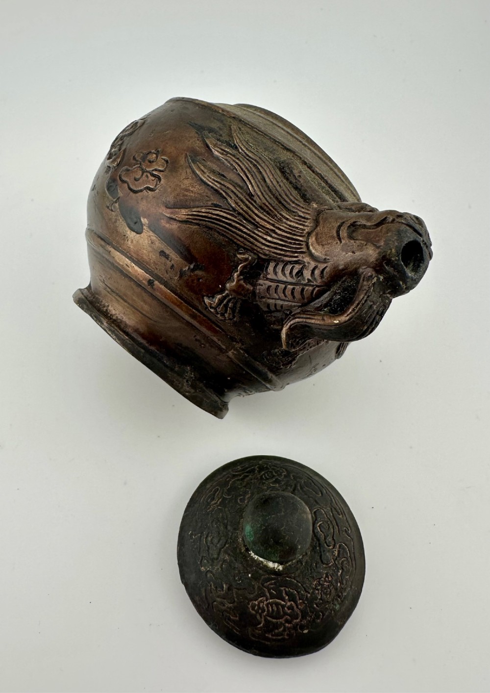 A dark cast bronze Chinese teapot featuring a sculpted dragon handle, a dragon-head spout, and raised Chinese character carvings on the main body. View X