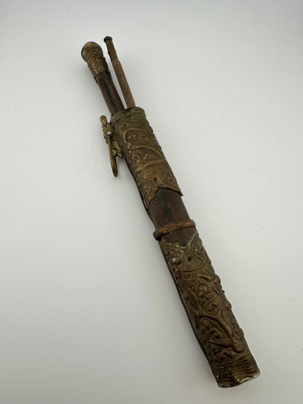 A 19th-century Chinese Qing Dynasty travelling eating set with chopsticks and knife stored inside an embossed brass-mounted sheath.