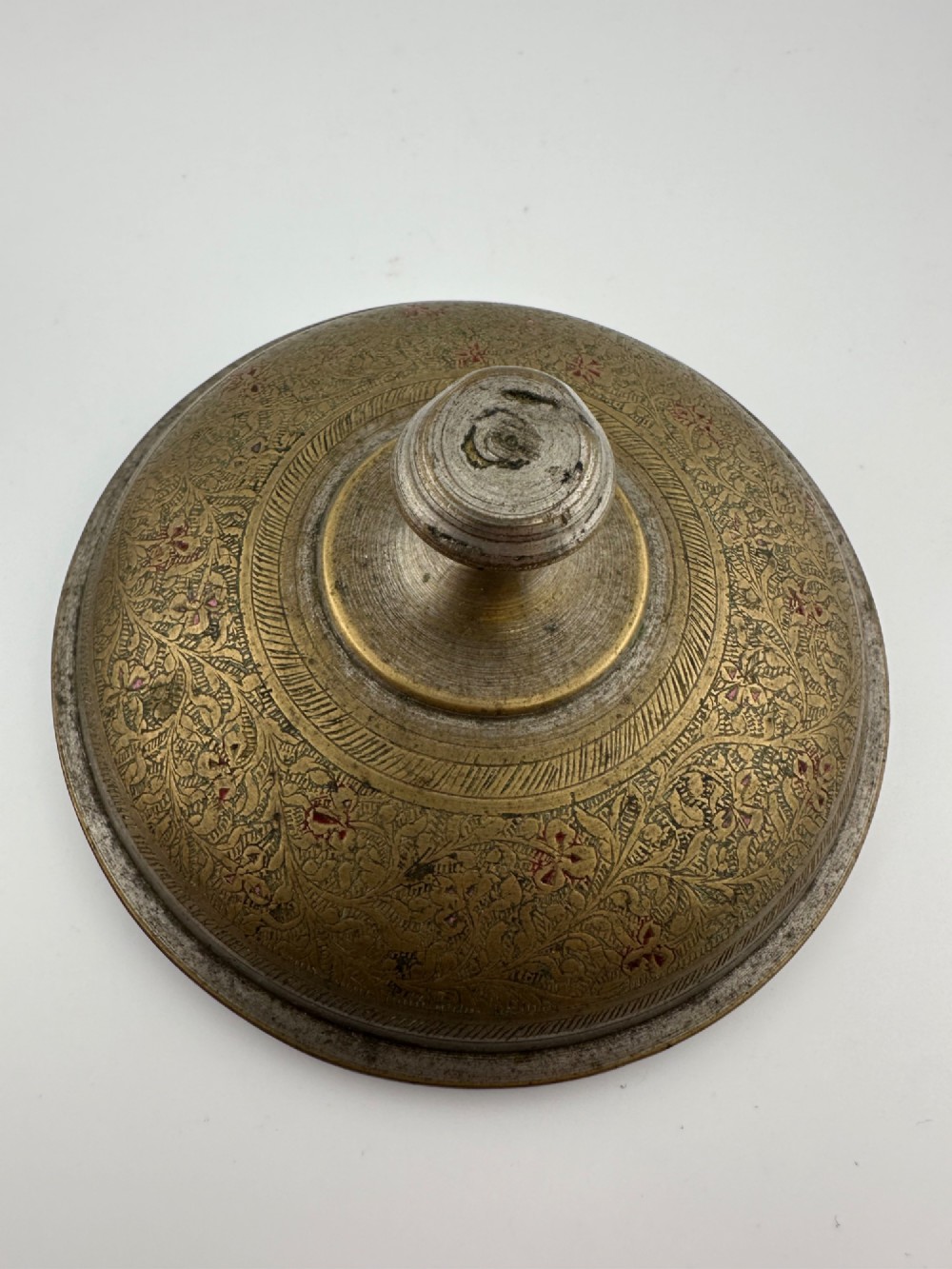 An antique domed Indian brass hand gong with detailed floral engravings, a turned central finial handle, and a dark wooden striker. View III