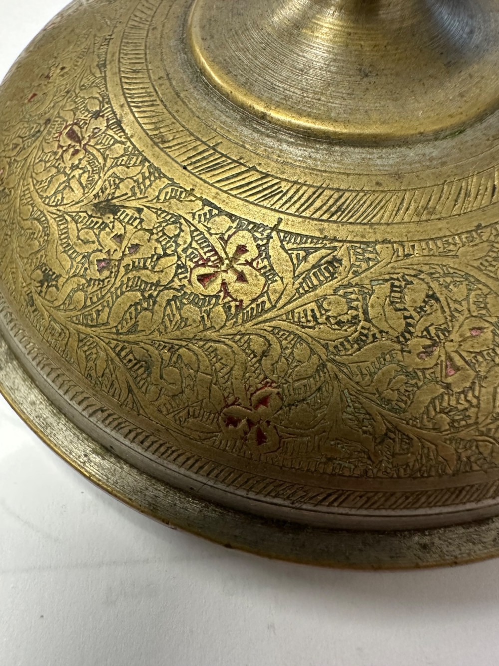 An antique domed Indian brass hand gong with detailed floral engravings, a turned central finial handle, and a dark wooden striker. View IX