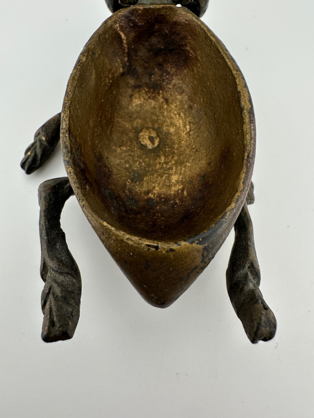 A cast dark brass match holder sculpted in the detailed shape of a fly with textured wings, compound eyes, and six legs. View V