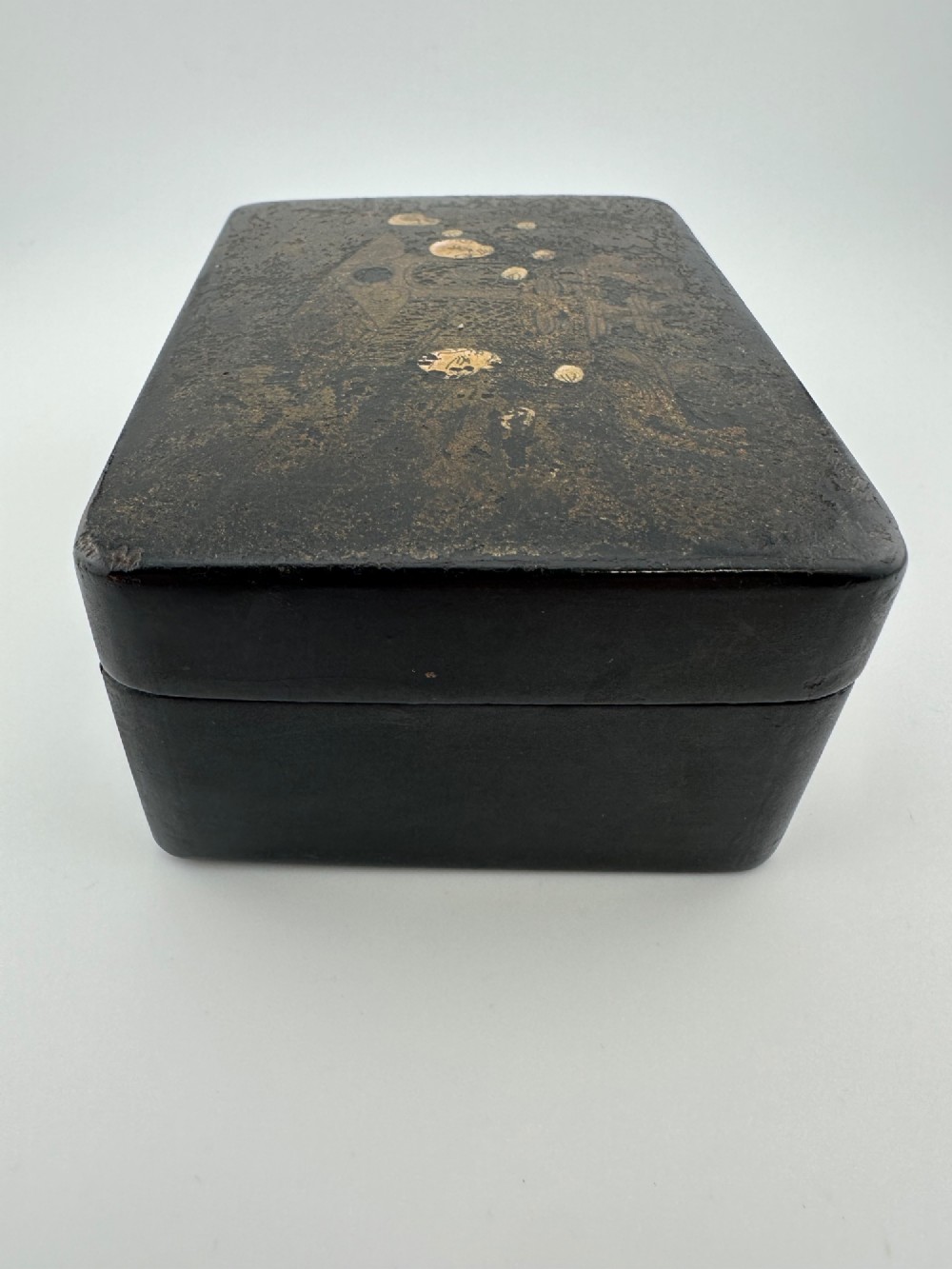An early 19th-century rectangular black lacquer box with gilded painted Chinese figural scenes on the lid. View IV