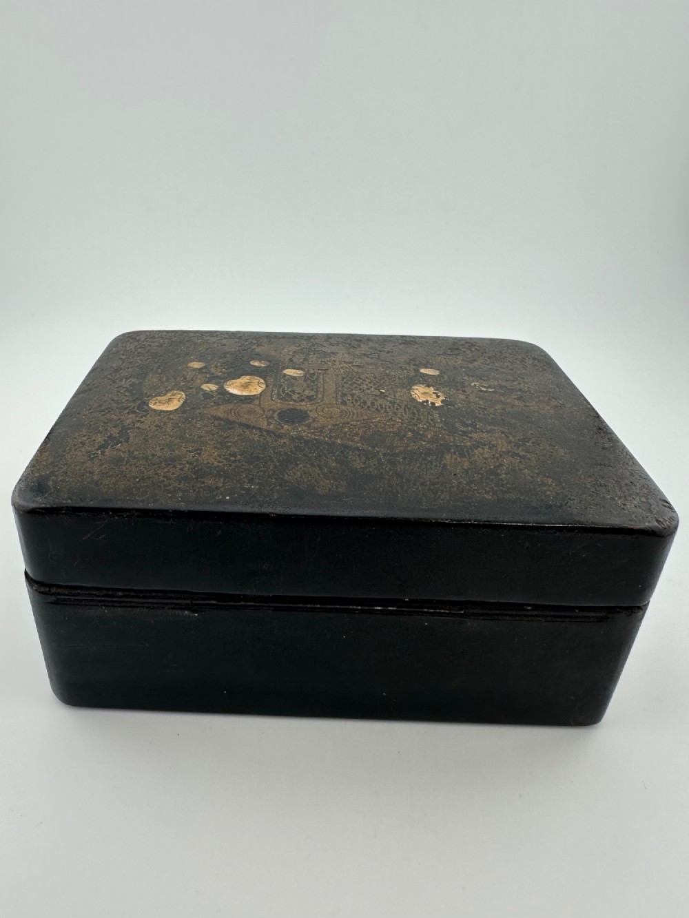 An early 19th-century rectangular black lacquer box with gilded painted Chinese figural scenes on the lid. View V