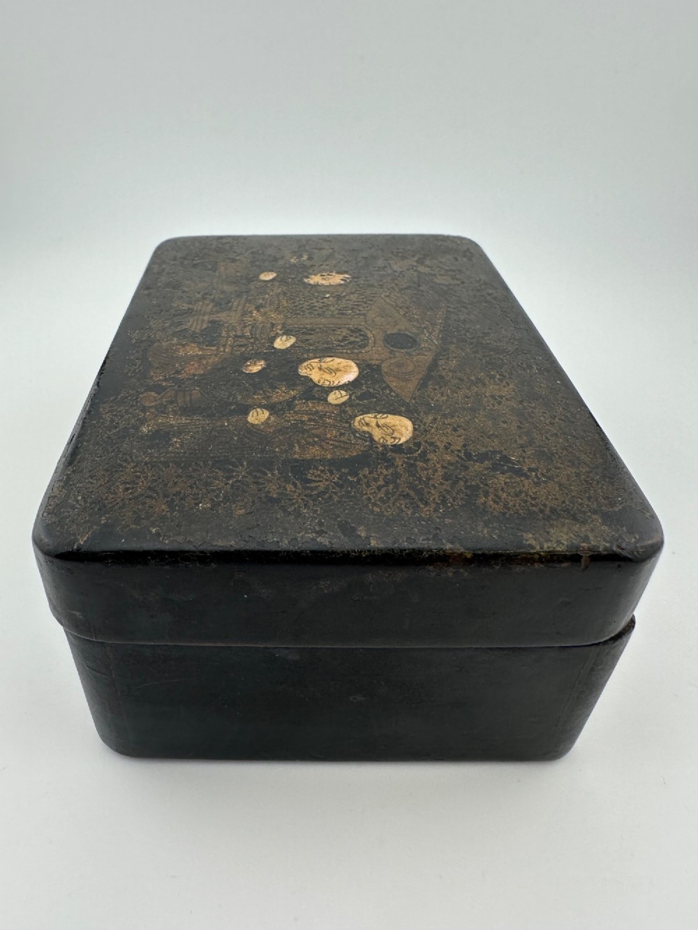 An early 19th-century rectangular black lacquer box with gilded painted Chinese figural scenes on the lid. View VI