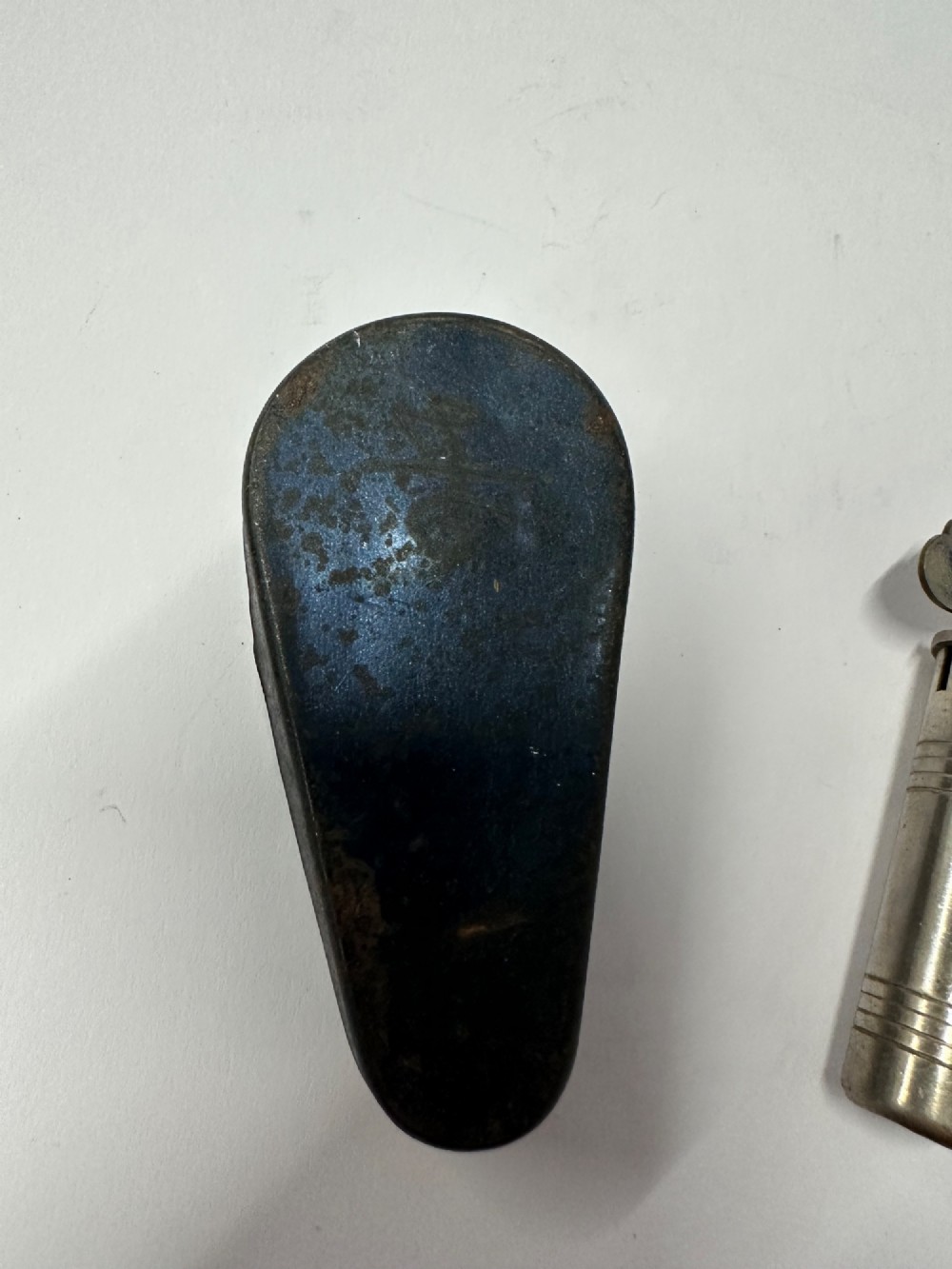 A cylindrical nickel-plated chromatic variable pitch pipe with a note scale arc sitting inside its open red metal case. View VII