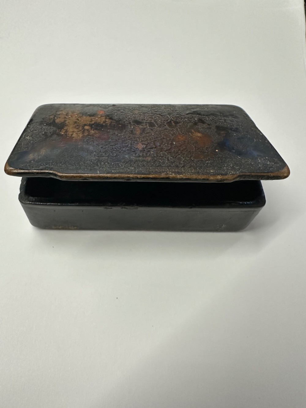 A small rectangular mid-19th-century Chinese export black lacquer box with a gilded decorated lid showing surface age and patina.