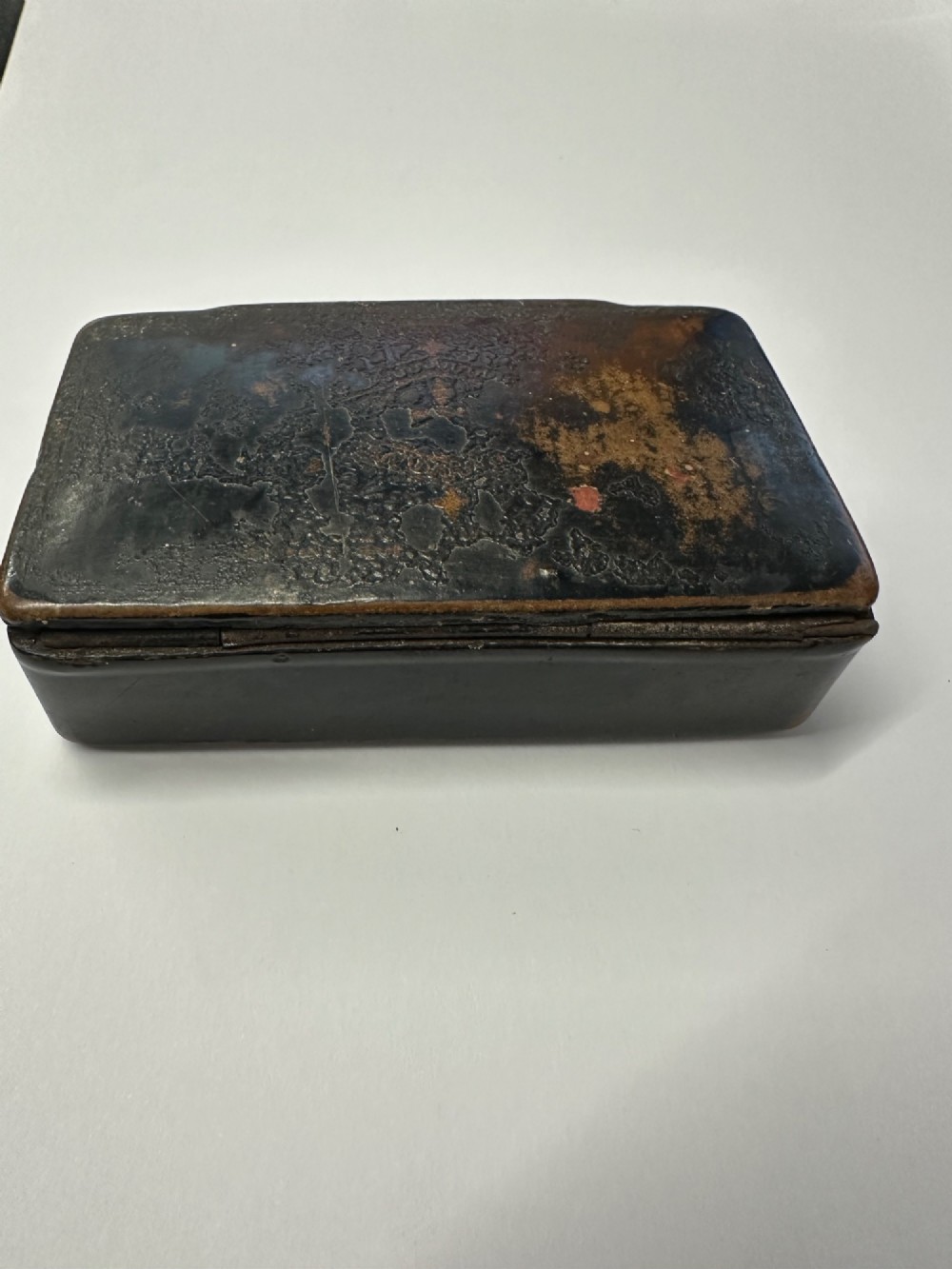 A small rectangular mid-19th-century Chinese export black lacquer box with a gilded decorated lid showing surface age and patina. View V