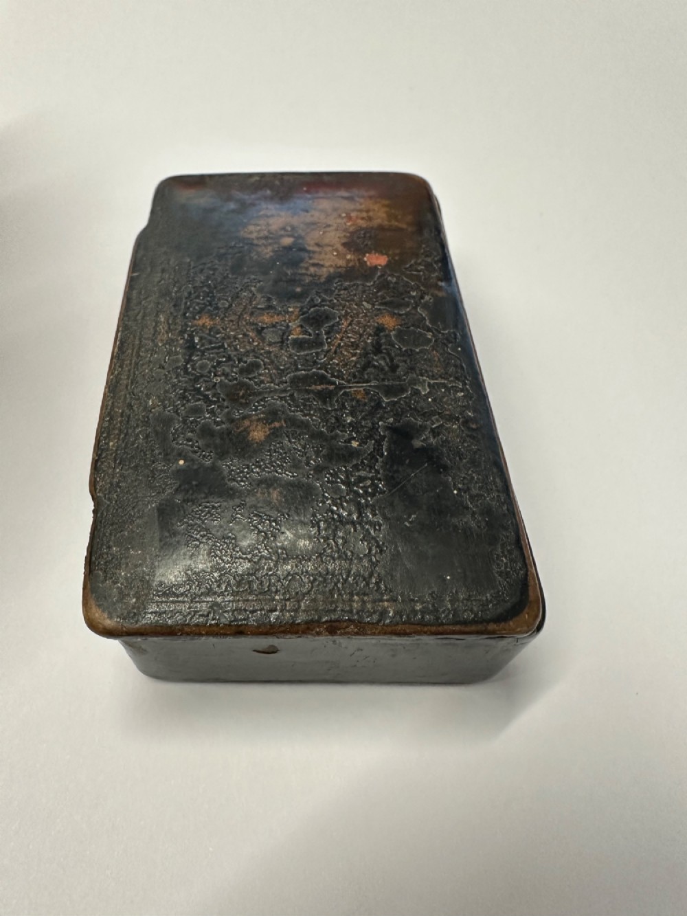 A small rectangular mid-19th-century Chinese export black lacquer box with a gilded decorated lid showing surface age and patina. View VI