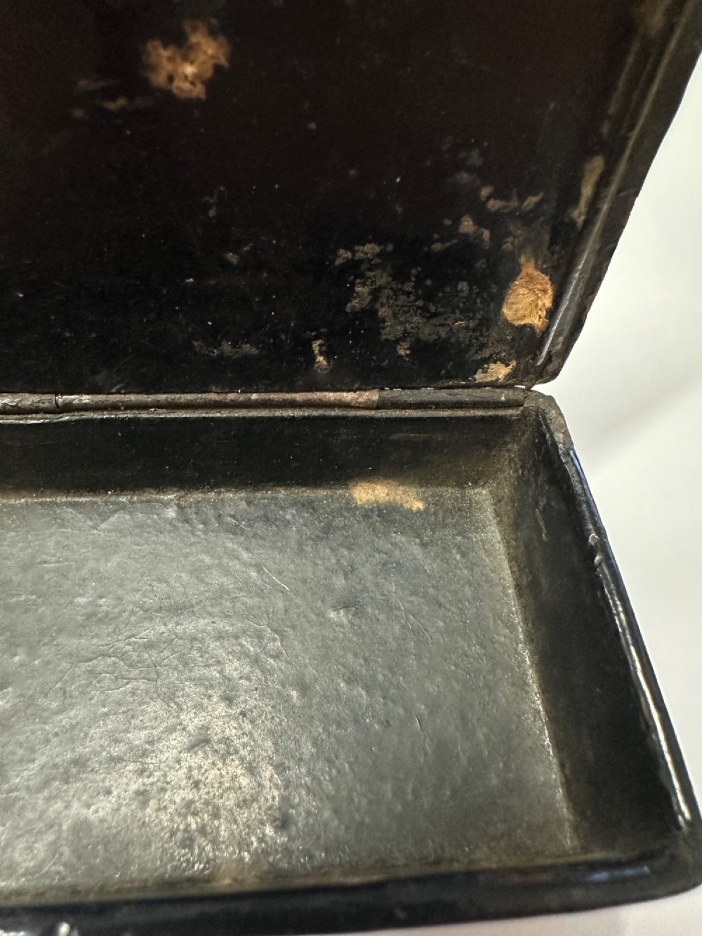 A small rectangular mid-19th-century Chinese export black lacquer box with a gilded decorated lid showing surface age and patina. View IX