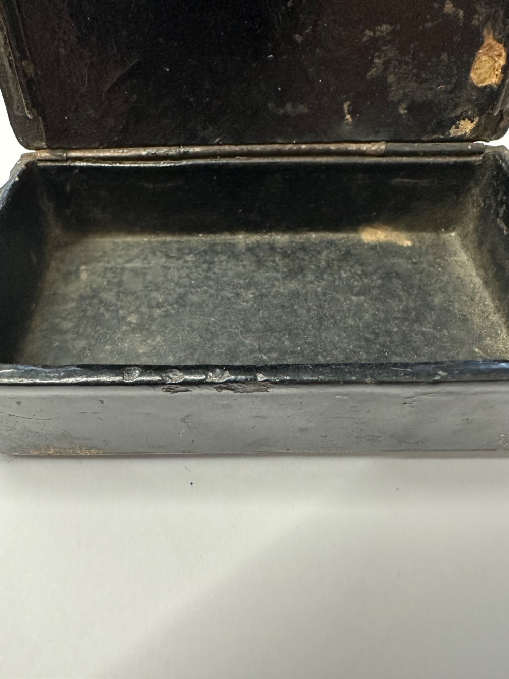A small rectangular mid-19th-century Chinese export black lacquer box with a gilded decorated lid showing surface age and patina. View X