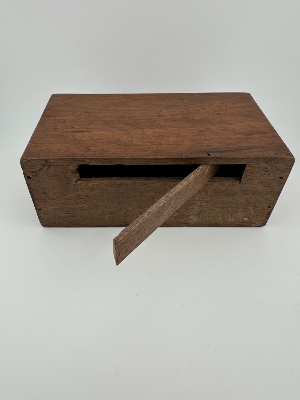 A rectangular dark wooden church collection box featuring a coin slot on top and a printed yellow and red Society for the Propagation of the Gospel label on the front. View X