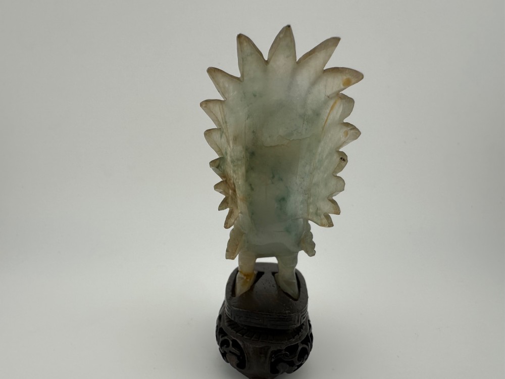 A hand-carved pale green jade sculpture of a cockerel with fan-shaped tail feathers, displayed on a dark carved hardwood base. View IV