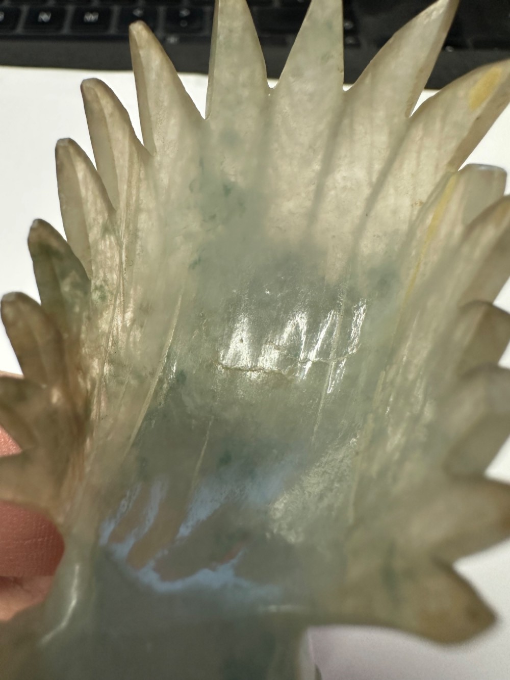 A hand-carved pale green jade sculpture of a cockerel with fan-shaped tail feathers, displayed on a dark carved hardwood base. View XIII