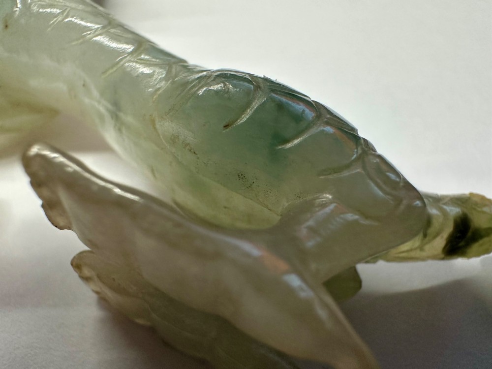 A carved pale green jade dragon sculpture shown alongside a dark pierced hardwood display stand. View VIII