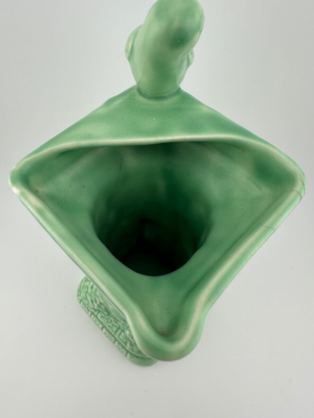 A pale green glazed earthenware Art Deco ceramic jug featuring relief brickwork and a sculpted bird perched on the handle. View IV