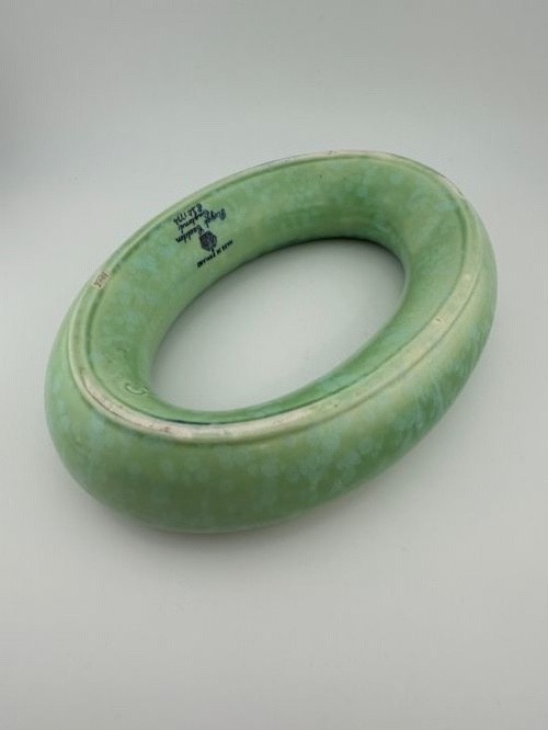 A 1930s oval ceramic posy ring vase with a mottled green glaze, featuring a hollow ring trough designed for short floral stems. View VI