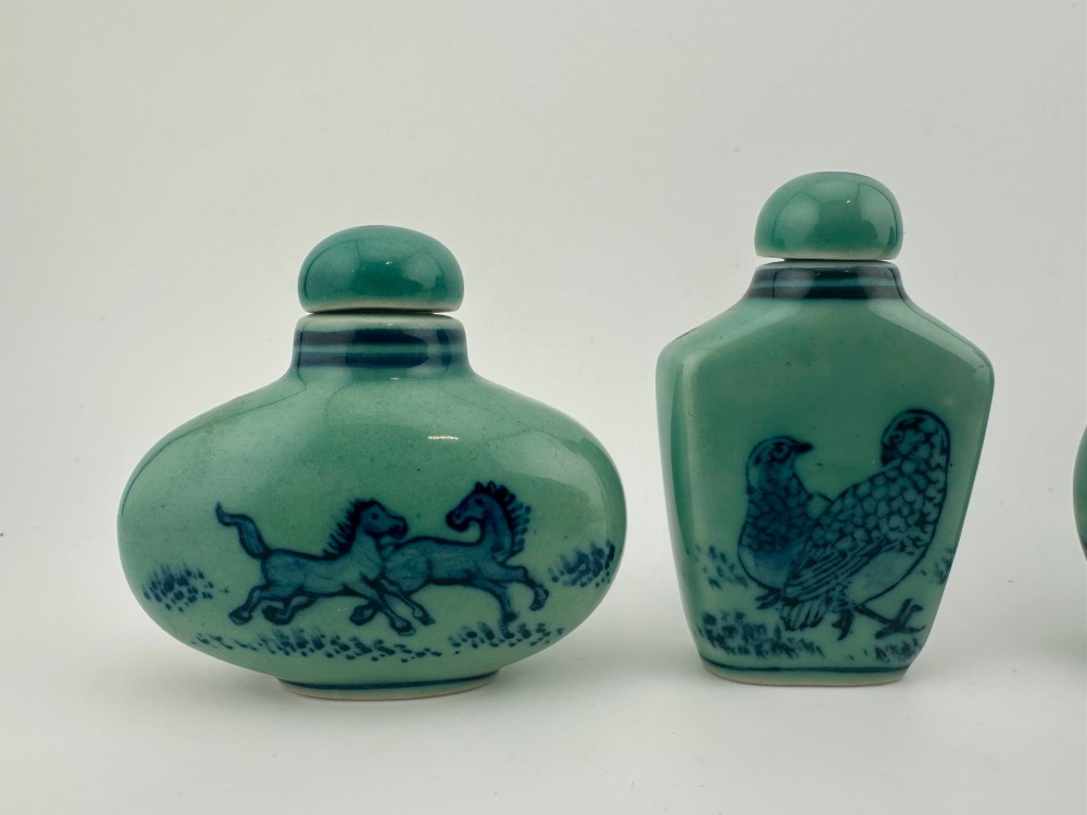 A set of four celadon-green porcelain snuff bottles painted with underglaze blue depictions of horses and birds. View III