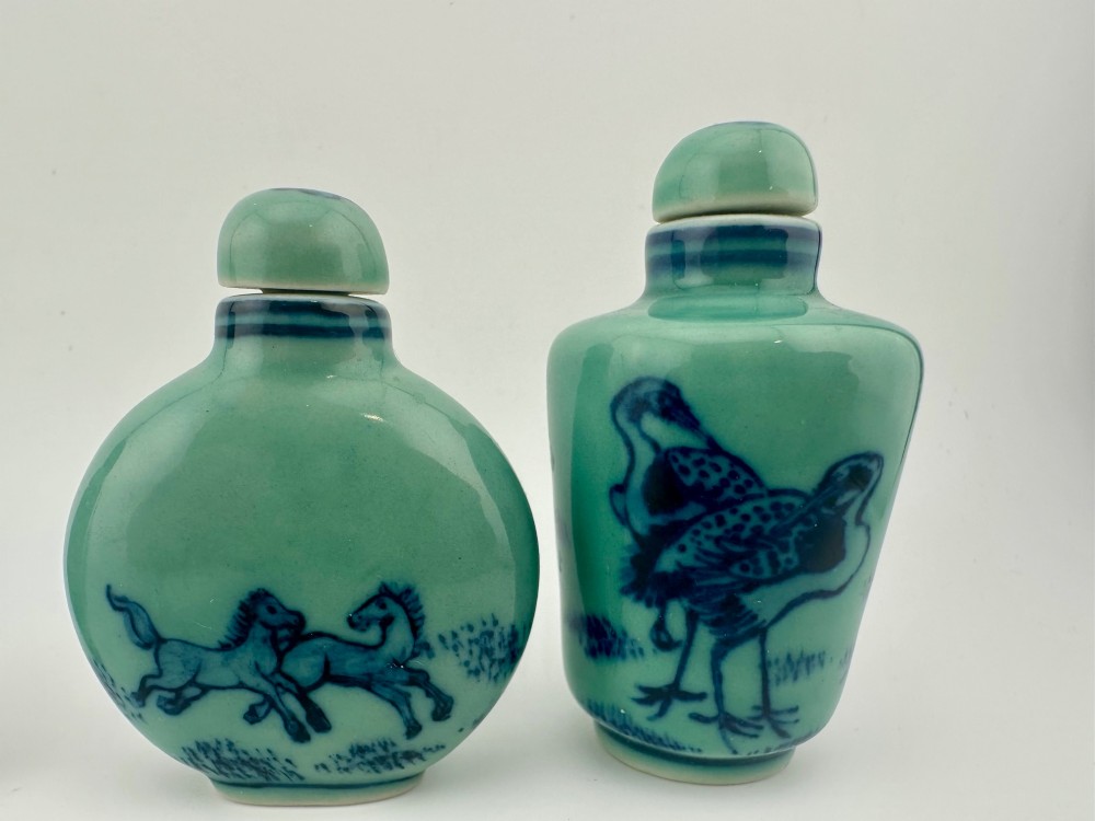 A set of four celadon-green porcelain snuff bottles painted with underglaze blue depictions of horses and birds. View IV