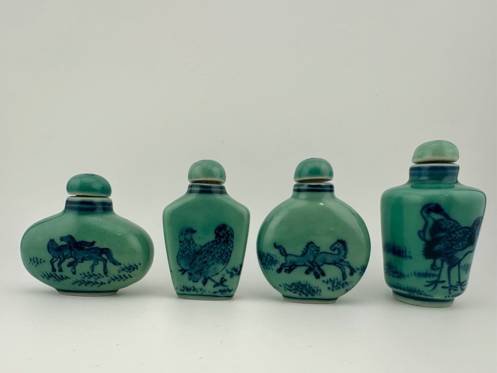 A set of four celadon-green porcelain snuff bottles painted with underglaze blue depictions of horses and birds. View V