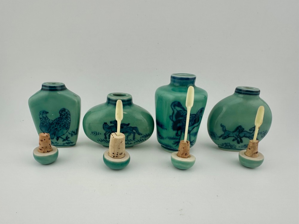 A set of four celadon-green porcelain snuff bottles painted with underglaze blue depictions of horses and birds. View IX