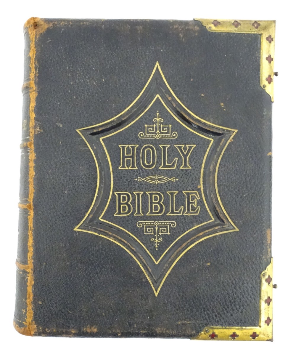 A dark leather-bound Victorian Holy Bible featuring gilt lettering inside a star-shaped frame and decorative brass corner mounts.