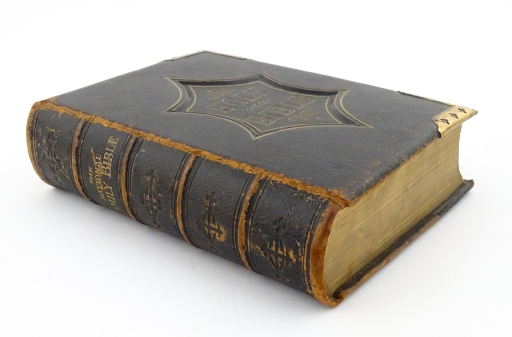 A dark leather-bound Victorian Holy Bible featuring gilt lettering inside a star-shaped frame and decorative brass corner mounts. View V