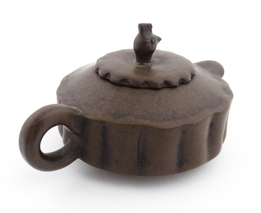A small dark brown unglazed ceramic teapot featuring a lobed body and a bird-shaped finial on the lid. View IX