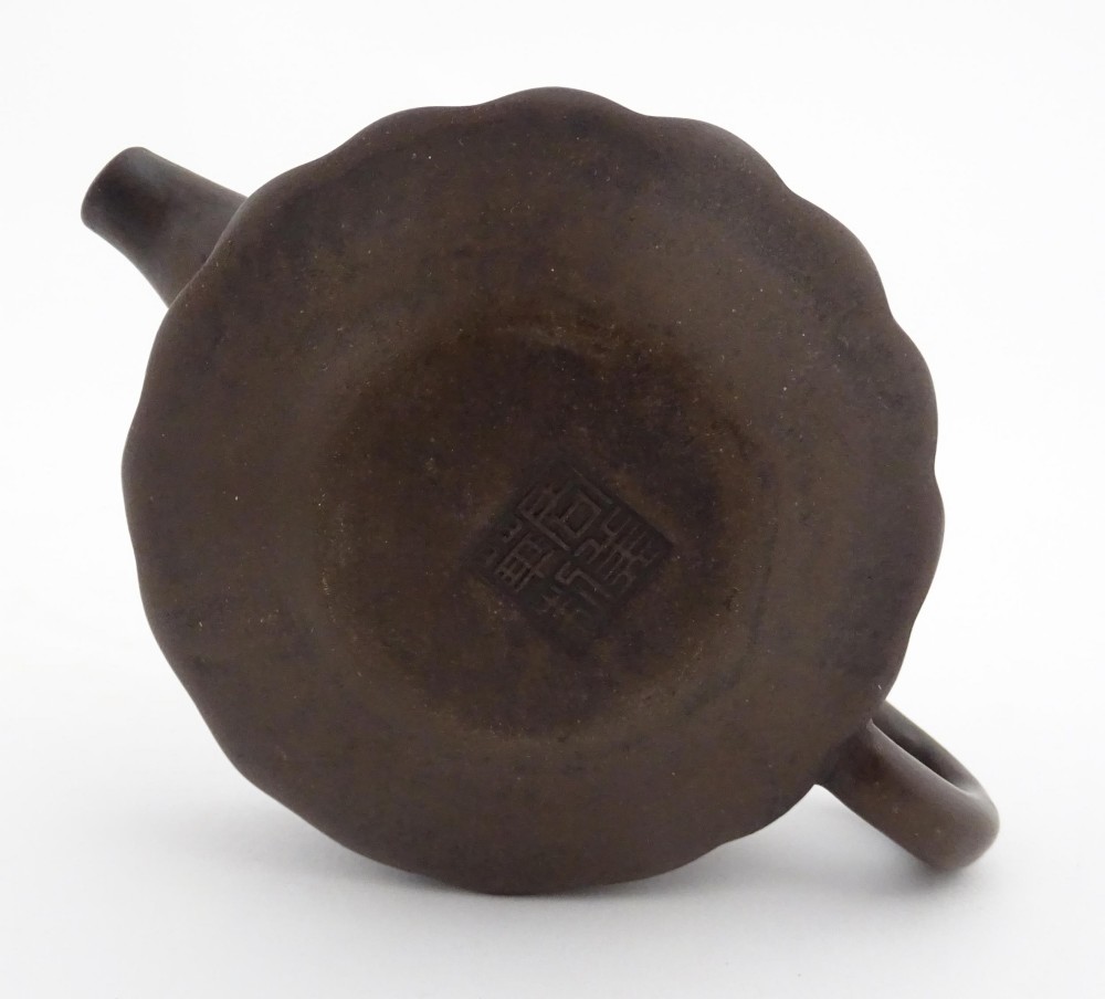 A small dark brown unglazed ceramic teapot featuring a lobed body and a bird-shaped finial on the lid. View XIII