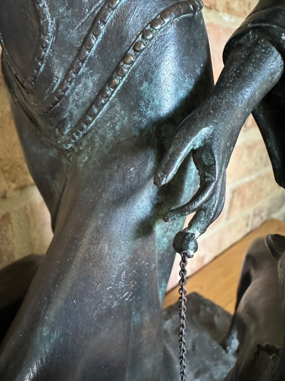 A dark bronze Art Deco sculpture depicting a stylised woman walking two greyhounds on thin chains, set on a dark polished marble base. View X