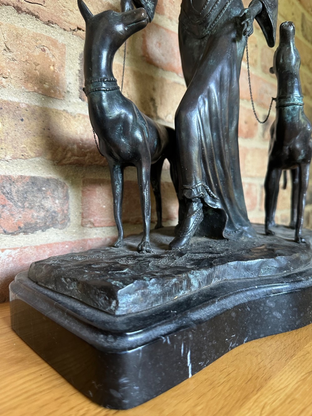 A dark bronze Art Deco sculpture depicting a stylised woman walking two greyhounds on thin chains, set on a dark polished marble base. View XI