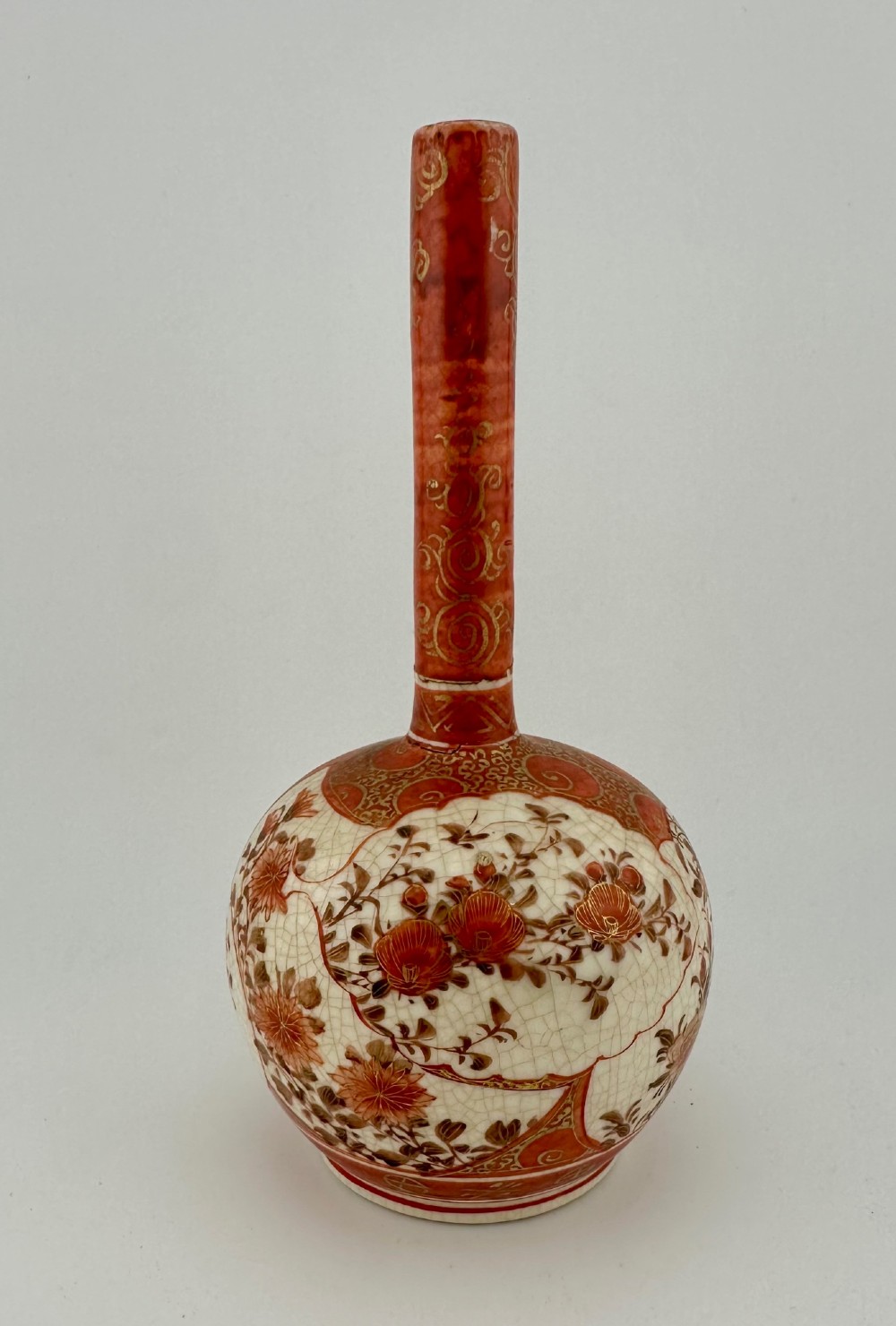 A Japanese Kutani porcelain bottle vase with a tall narrow neck, featuring iron red and gilt floral decoration over a cream crackle glaze body. View II