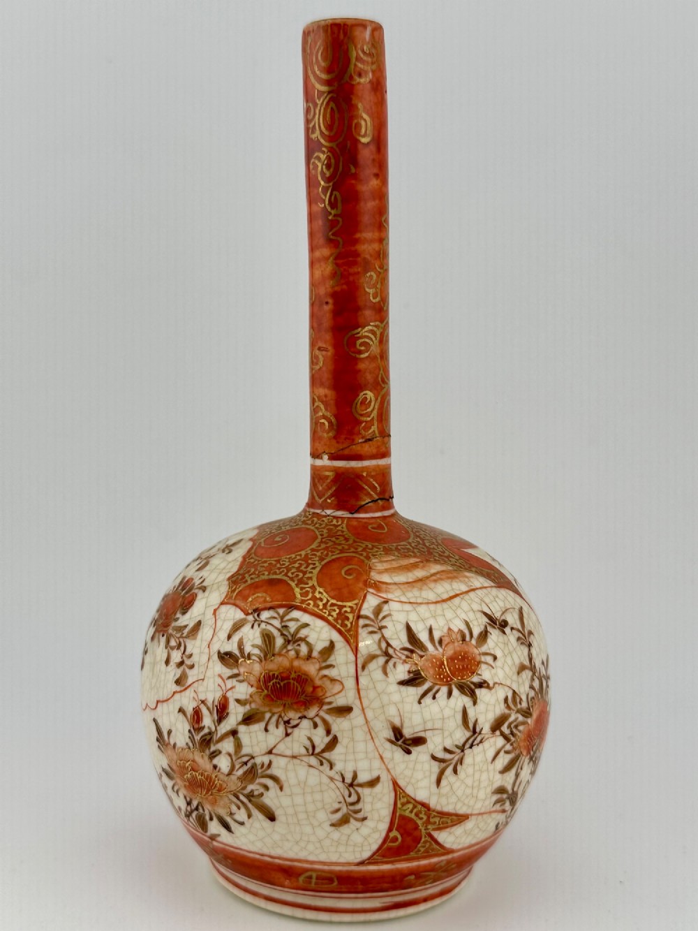 A Japanese Kutani porcelain bottle vase with a tall narrow neck, featuring iron red and gilt floral decoration over a cream crackle glaze body. View VIII