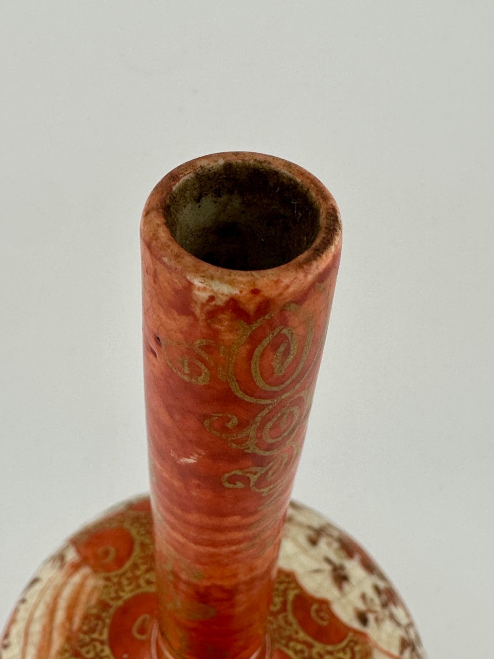 A Japanese Kutani porcelain bottle vase with a tall narrow neck, featuring iron red and gilt floral decoration over a cream crackle glaze body. View IX