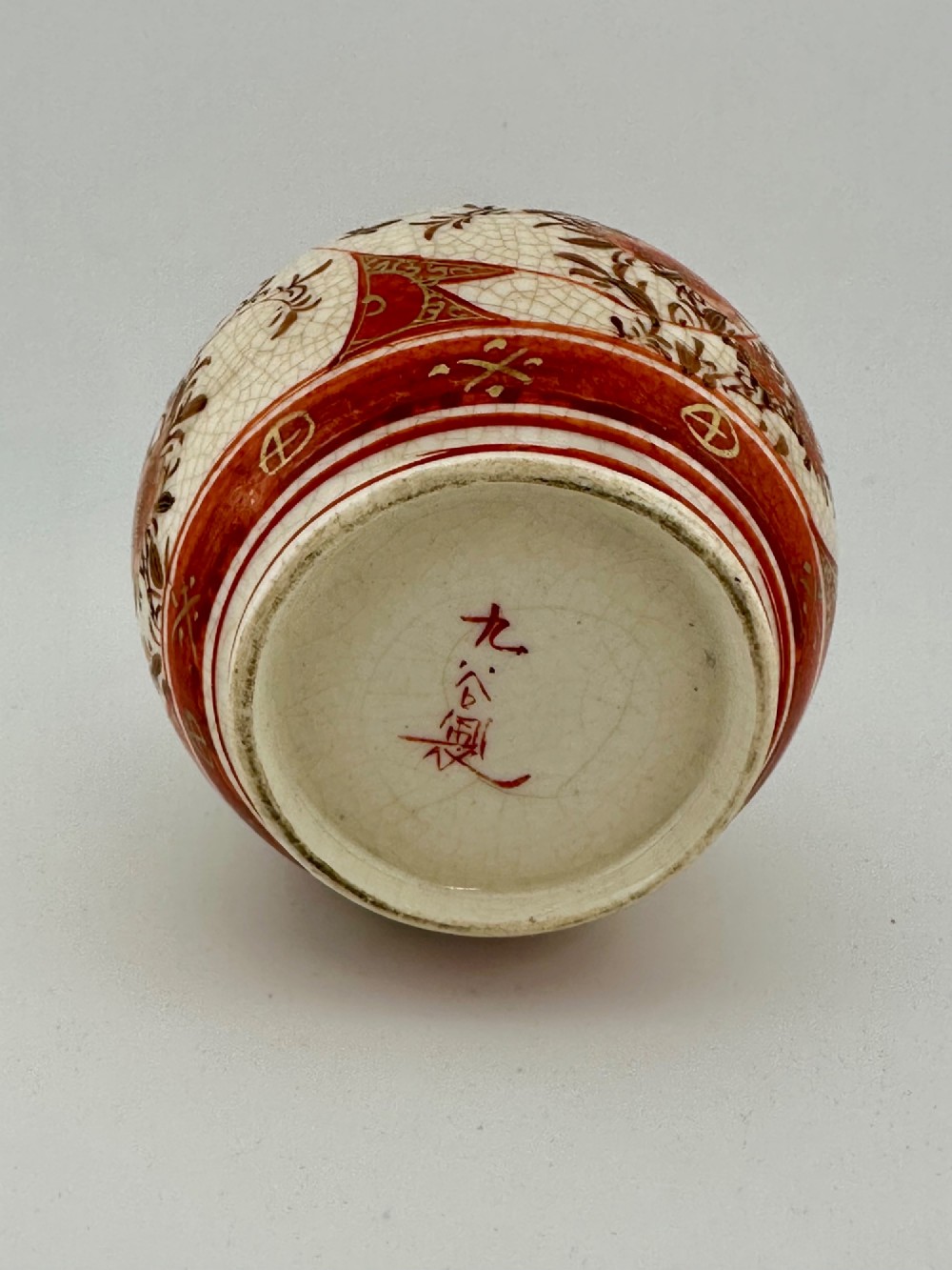 A Japanese Kutani porcelain bottle vase with a tall narrow neck, featuring iron red and gilt floral decoration over a cream crackle glaze body. View XIV