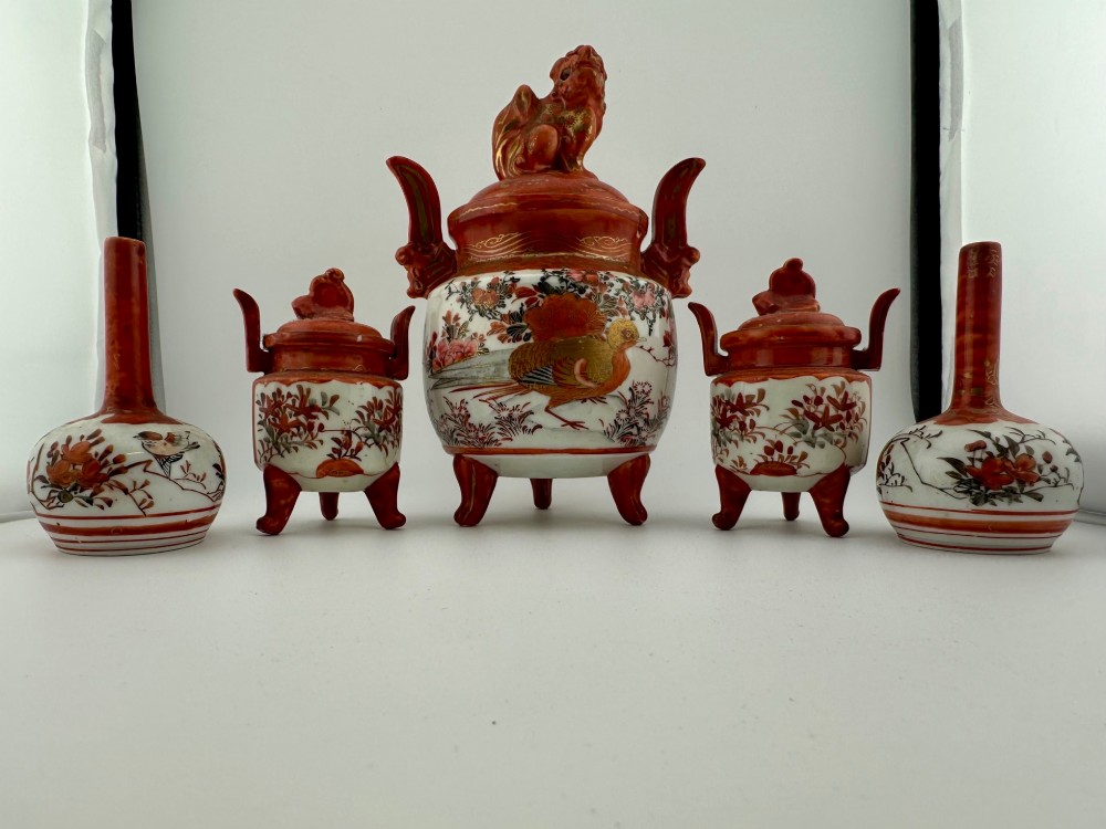 A five-piece Japanese Kutani porcelain garniture set featuring three tripod censers with shishi lion lids and two bottleneck vases in iron-red and polychrome enamel detailing. View II