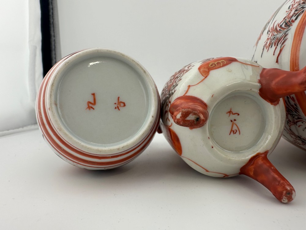 A five-piece Japanese Kutani porcelain garniture set featuring three tripod censers with shishi lion lids and two bottleneck vases in iron-red and polychrome enamel detailing. View VIII