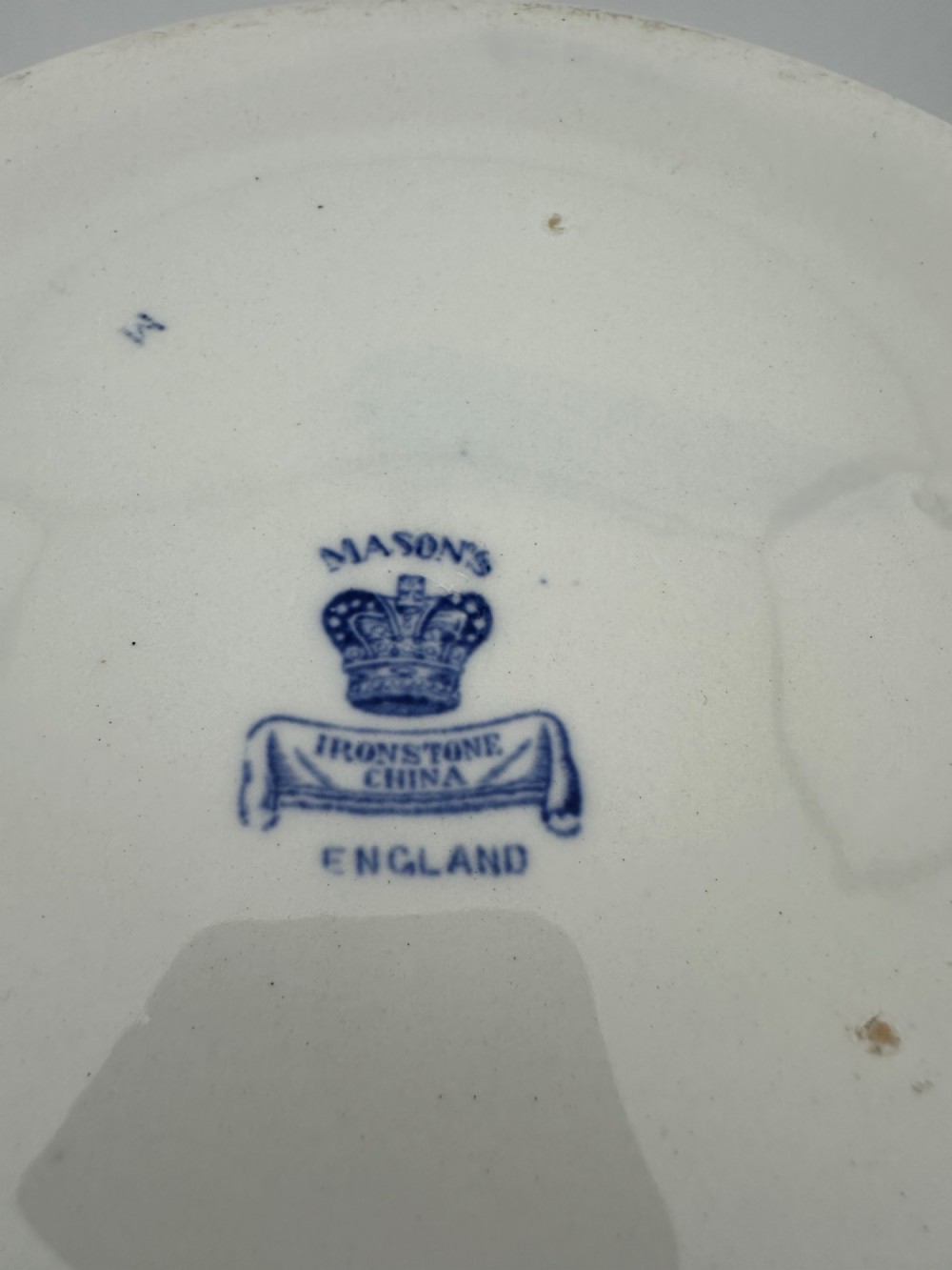 A circular antique blue and white ironstone wash basin bowl featuring a central Chinoiserie landscape scene surrounded by ornate floral and geometric borders. View VI