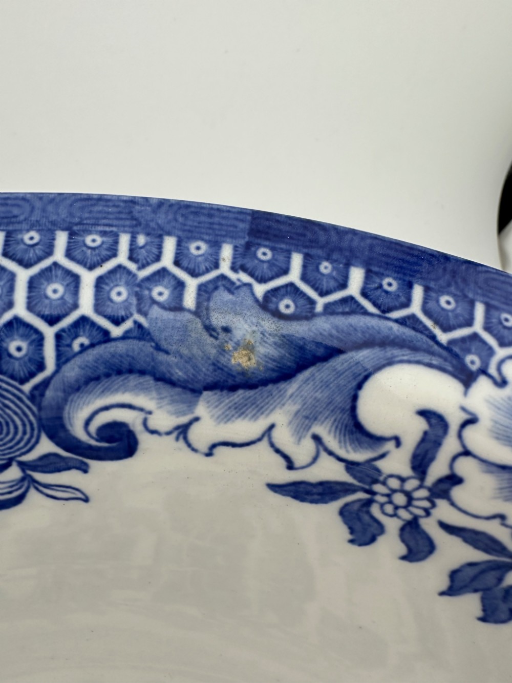 A circular antique blue and white ironstone wash basin bowl featuring a central Chinoiserie landscape scene surrounded by ornate floral and geometric borders. View VIII