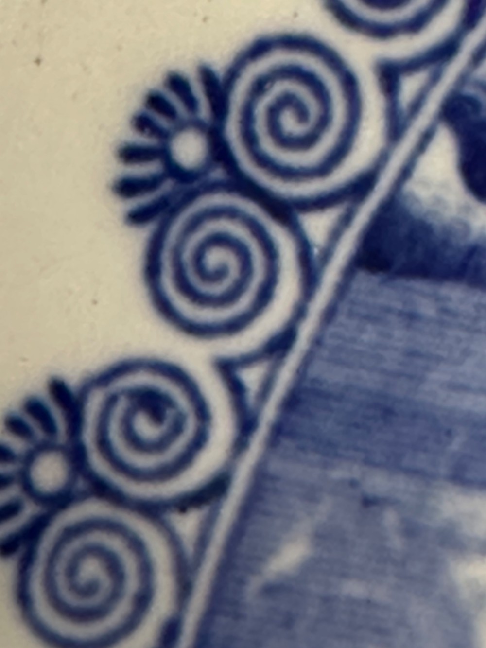 A circular antique blue and white ironstone wash basin bowl featuring a central Chinoiserie landscape scene surrounded by ornate floral and geometric borders. View XIV