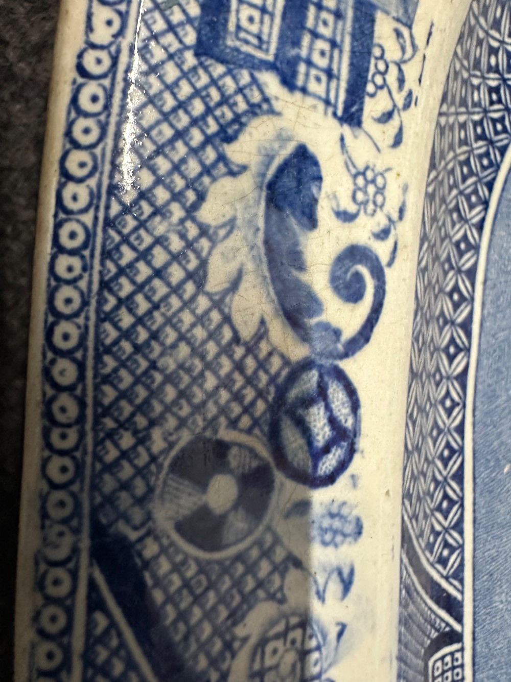 An oval early Victorian Staffordshire earthenware meat platter featuring a cobalt blue and white transferware Willow pattern with pagodas, birds, and a decorative geometric border. View IV