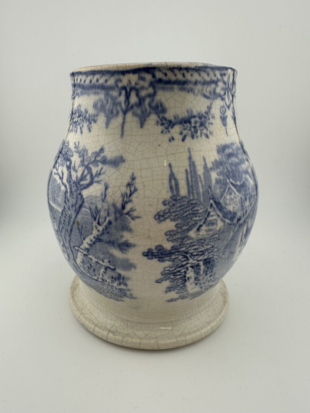 An early Victorian blue and white transferware ceramic jug featuring a pastoral cattle scene with fine glaze crazing throughout. View V
