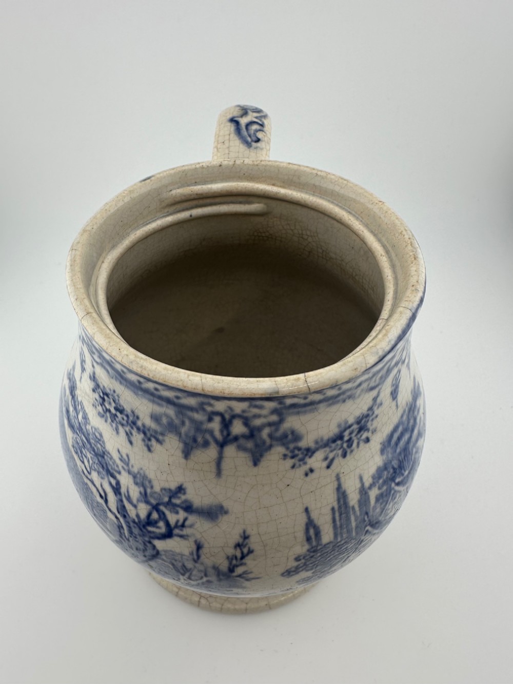 An early Victorian blue and white transferware ceramic jug featuring a pastoral cattle scene with fine glaze crazing throughout. View VI